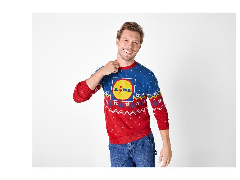 Muž v modro-červenom vianočnom svetri Lidl a džínsoch.