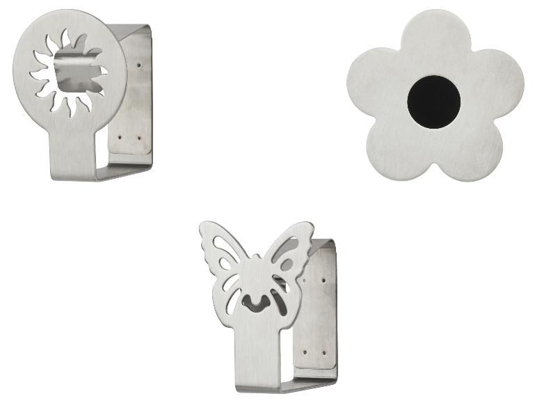 Tri nástenné držiaky z brúseného kovu: slnko, kvet a motýľ.