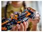 Osoba drží čierne a oranžové pretekárske auto LEGO McLaren Formuly 1.
