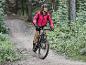 Žena jazdí na horskom bicykli v lese.