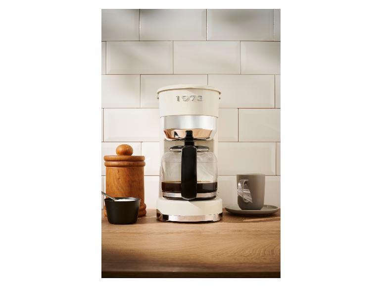 Krémová kávovar 1973 na drevenom stole.