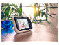 Motorola baby monitor zobrazuje roztomilé bábätko na drevenom stole.