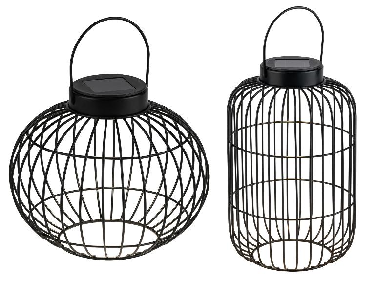 Dve čierne kovové dekoratívne solárne lampáše, jeden guľatý a jeden valcový.
