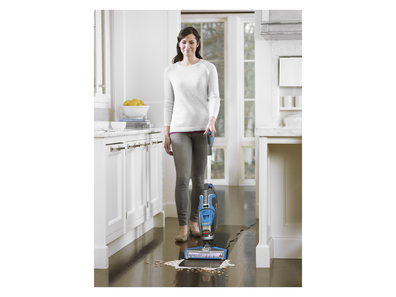 Žena používa vysávač Bissell CrossWave v kuchyni.