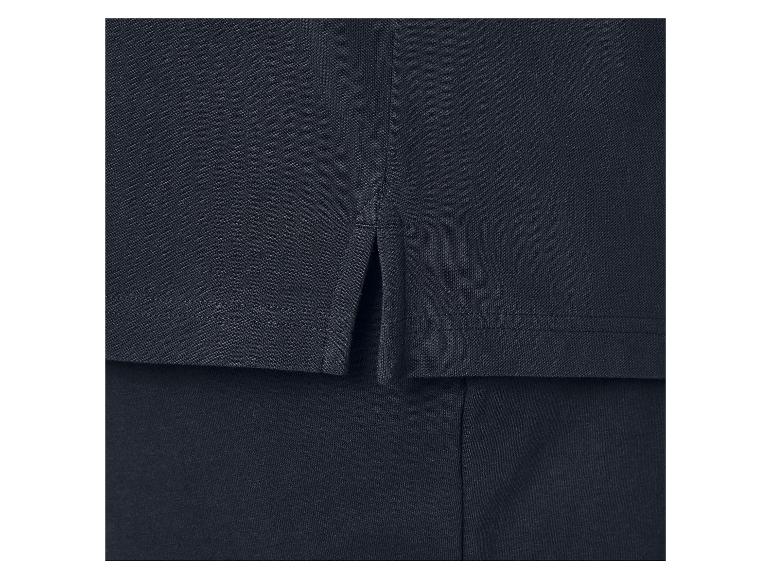 Detail tmavomodrého polo trička s bočnými rozparkami.