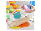 Play-Doh plastelína a drevené nástroje v detských rukách.