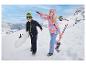 Dve deti v zimnom oblečení s lyžami a snowboardom v zasneženej krajine.
