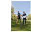 Dve osoby kráčajú parkom s palicami na nordic walking.
