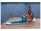 Muž skladá nafukovací paddleboard na móle.