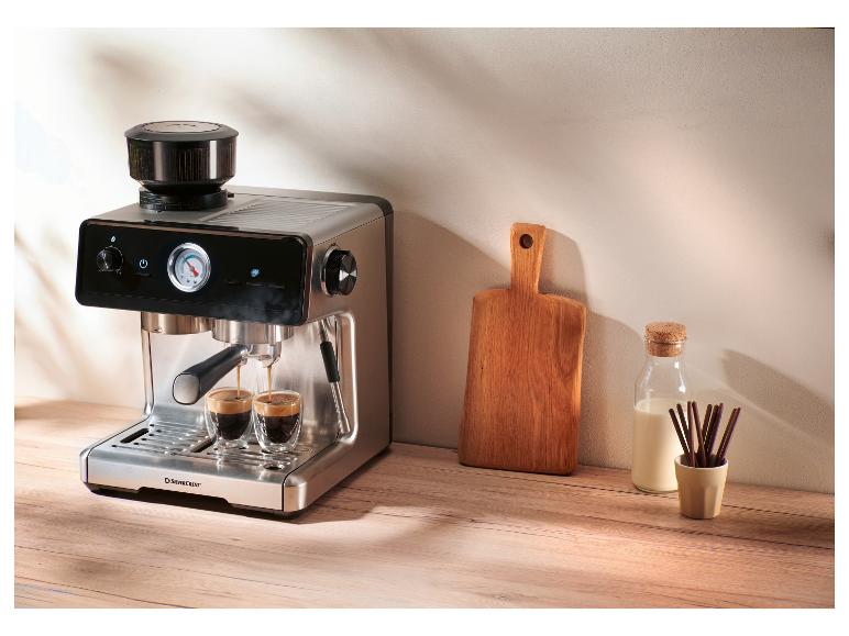 Espresso kávovar s integrovaným mlynčekom pripravuje dve kávy, vedľa fľaše mlieka a dosky na krájanie.