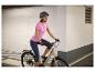 Žena na elektrickom bicykli s prilbou a športovým oblečením.