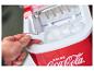 Ruka berie ľadové kocky z červeného výrobníka ľadu Coca-Cola.
