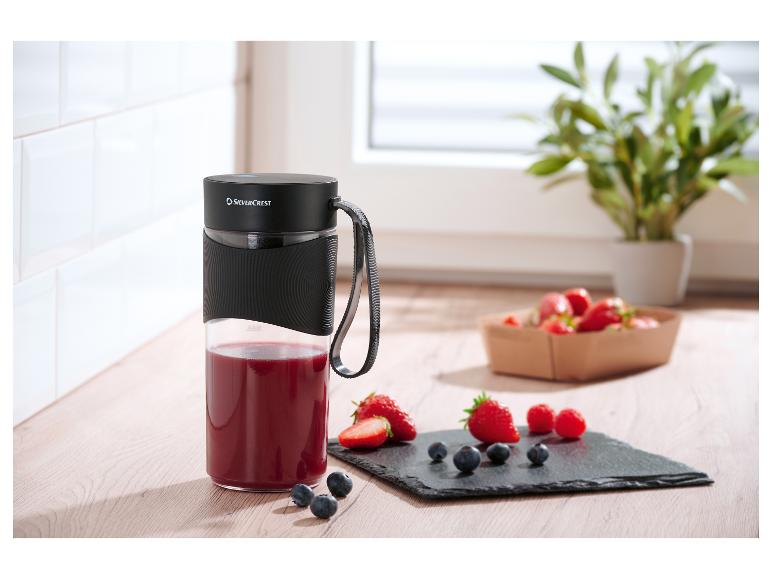 Prenosný mixér SilverCrest s červeným smoothie a čerstvým ovocím na drevenej doske.