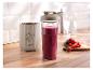 Smoothie mixér SilverCrest s fľašou plnou ovocného smoothie a čerstvým ovocím na drevenej doske.