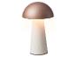 Stolná lampa v tvare huby s ružovo-zlatým vrchom a bielou základňou, vydávajúca teplé svetlo.