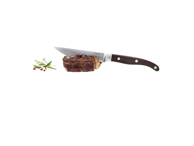 Steak s nožom, rozmarínom a korením na bielom pozadí.