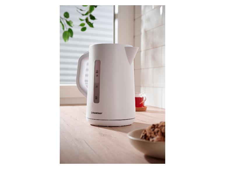 Biely rýchlovarná kanvica SilverCrest na drevenej doske s šálkou čaju.