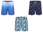 Tri plavky značky Happy Shorts, jedna s modrým ombre vzorom, jedna s pelikánmi a jedna s tropickou potlačou.