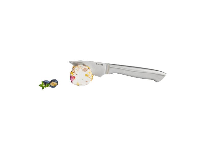 Nôž krája kúsok syra s kvetmi, vedľa čučoriedok a mäty.