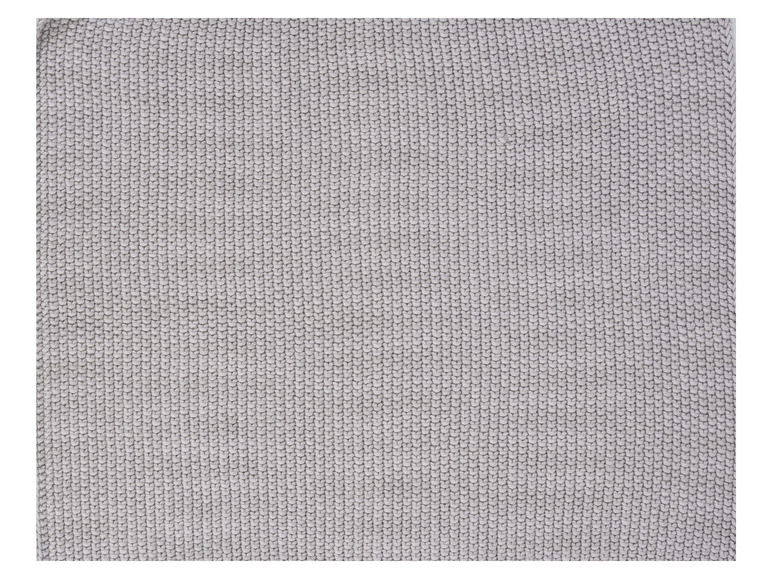 Detailný záber na sivú pletenú látku.