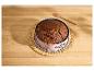 Čokoládová torta v ružovej tortovej forme na prútenej podložke, s kuchynským štetcom.