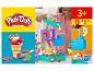 Súprava na výrobu zmrzliny Play-Doh s dievčaťom vyrábajúcim zmrzlinu a kornútkom s farebnou Play-Doh hmotou.