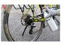 Ruka v rukavici maže reťaz bicykla sprejom Parkside.