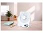 Biely stolný ventilátor s digitálnym displejom 60° na drevenom stole s poznámkovými blokmi a perami.