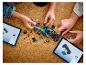 Dve osoby stavajú LEGO Formulu 1 auto s digitálnymi inštrukciami na tabletoch.