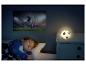 Dieťa spí v pyžame s hviezdami, futbalová nočná lampa a projekcia zápasu.