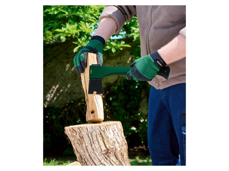 Osoba v zelených rukaviciach štiepa drevo sekerou Parkside.