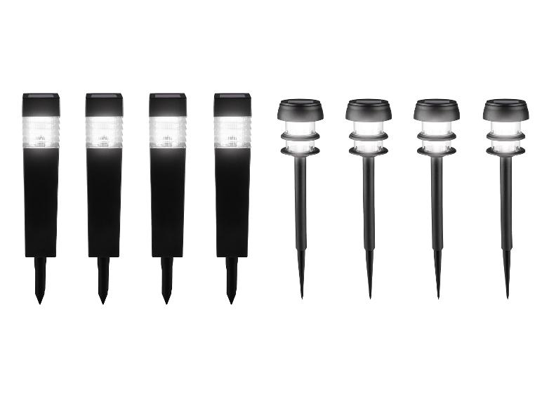 Osem čiernych solárnych záhradných svetiel, štyri štvorcové a štyri okrúhle.