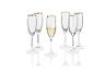 Sada šampánskych pohárov so zlatým okrajom, jeden z nich je naplnený.