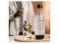 Fľaša SodaStream a pohár šumivého nápoja s bobuľami a mätou.