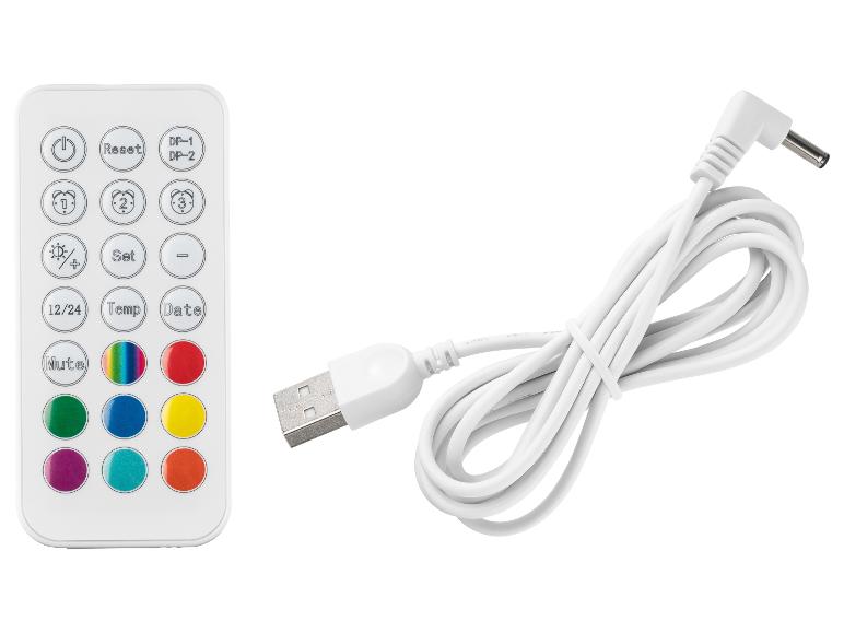 Biely diaľkový ovládač s farebnými tlačidlami a nabíjacím káblom USB.