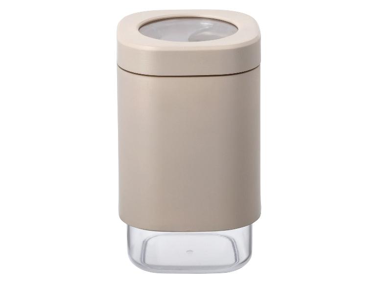 Béžová nádoba na korenie s priehľadným viečkom.