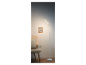 Moderná biela LED stojacia lampa pri kresle.