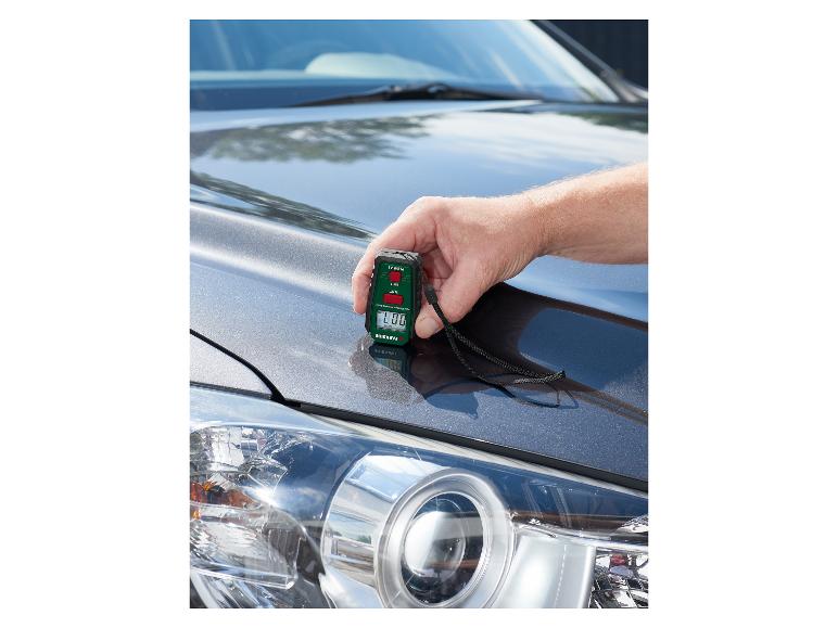 Muž používa merač hrúbky laku PARKSIDE na kapote auta.