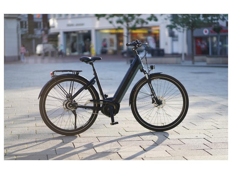 Čierny a sivý elektrobicykel zaparkovaný na dláždenom námestí v meste.
