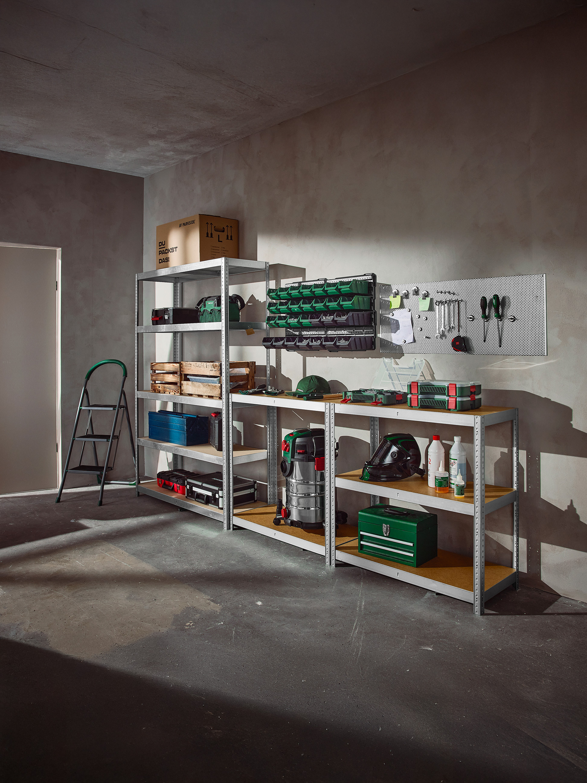 Organizovaná garáž s regálmi plnými náradia, úložných boxov a dielenského vybavenia.
