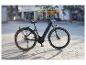 Čierny a sivý elektrobicykel zaparkovaný na dláždenom námestí v meste.
