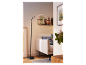 Čierna stojacia lampa s ohnutým ramenom osvetľuje modernú obývaciu izbu.