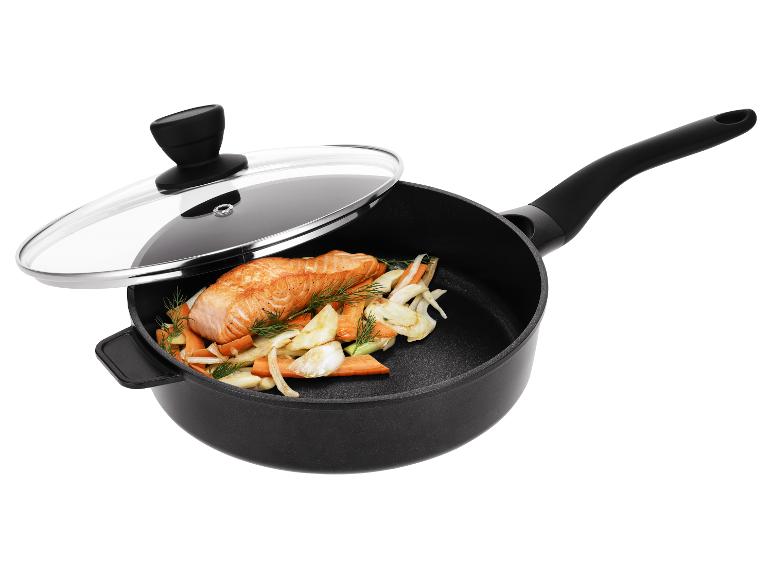 Čierna panvica so sklenenou pokrievkou, obsahujúca lososa a zeleninu.