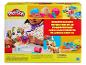 Súprava Play-Doh Pretend Pet Play s dieťaťom hrajúcim sa na veterinára so psou figúrkou a farebnou plastelínou.