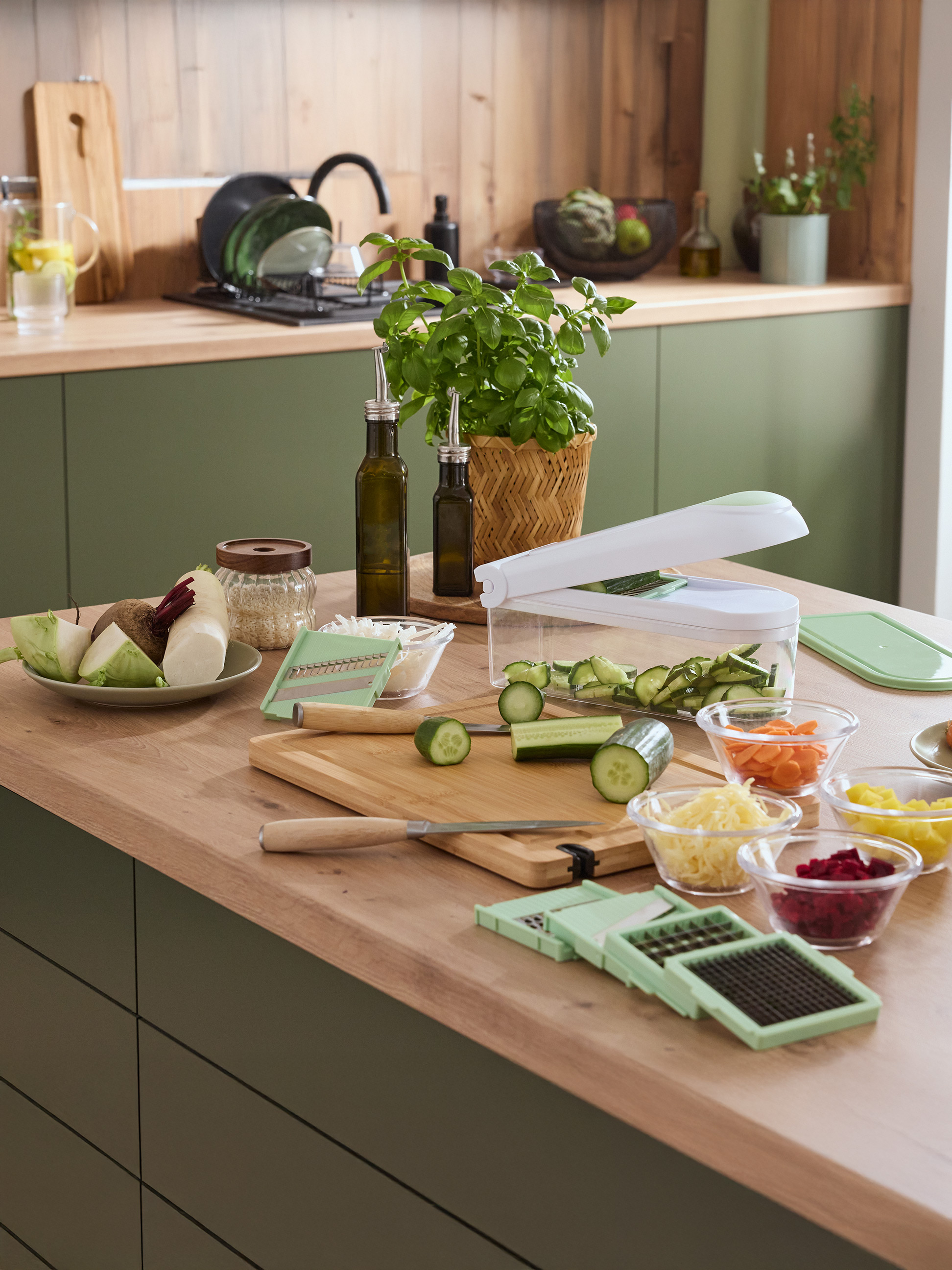 Kuchynská linka s krájačom na zeleninu, čerstvou zeleninou a bylinkami.