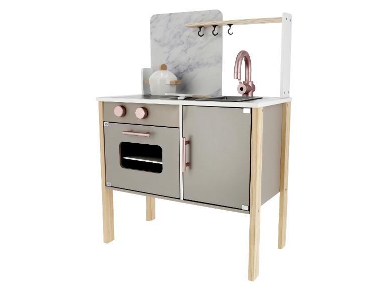 Moderná detská kuchynka s mramorovým obkladom, rúrou a drezom.