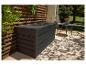 Tmavosivý záhradný úložný box na terase s drevenou mriežkou a záhradným nábytkom.