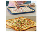 Tarte flambée s slaninou, cibuľou a smotanou pripravená na podávanie.