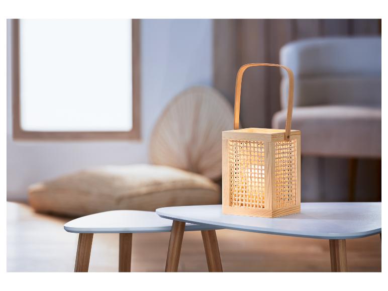 Drevená lampa s pleteným vzorom na bielom stolíku.