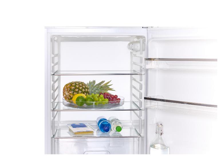 Otvorená chladnička s ovocím, fľašami vody a syrom.